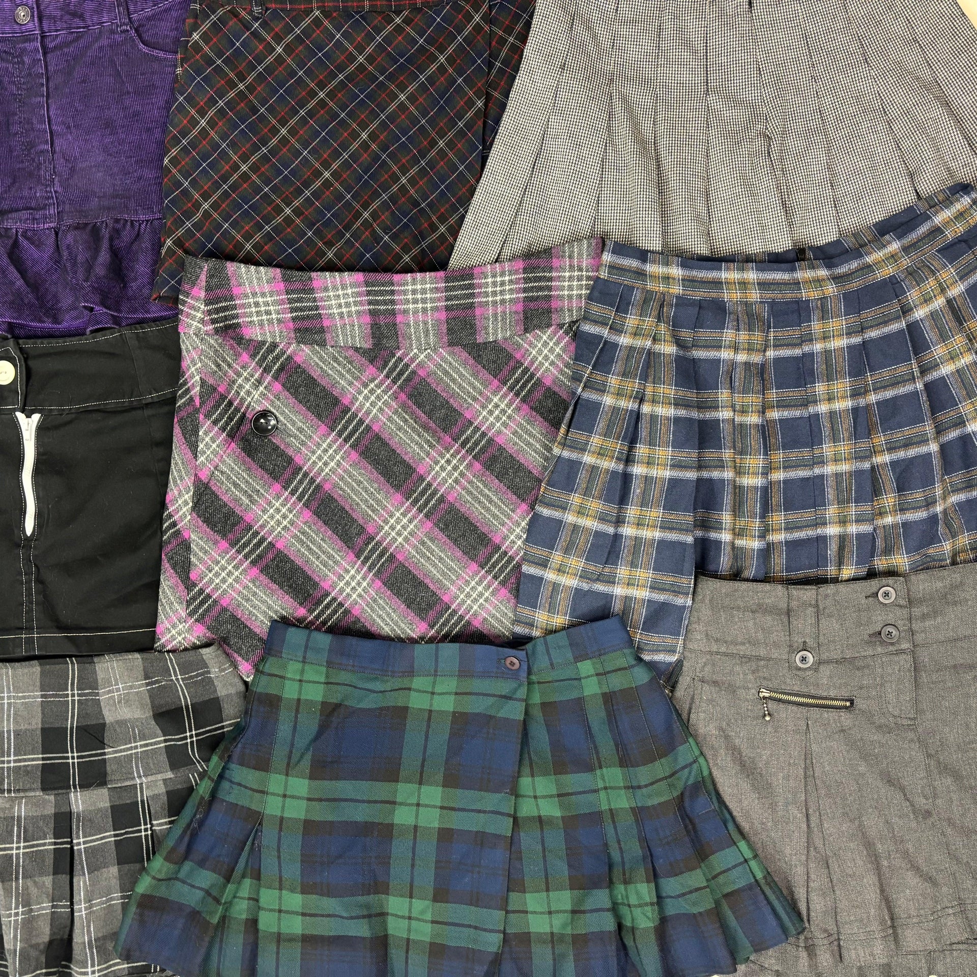 Assorted autumn winter mini skirts in various plaid patterns and colors including purple, gray, pink, blue, green, and black .