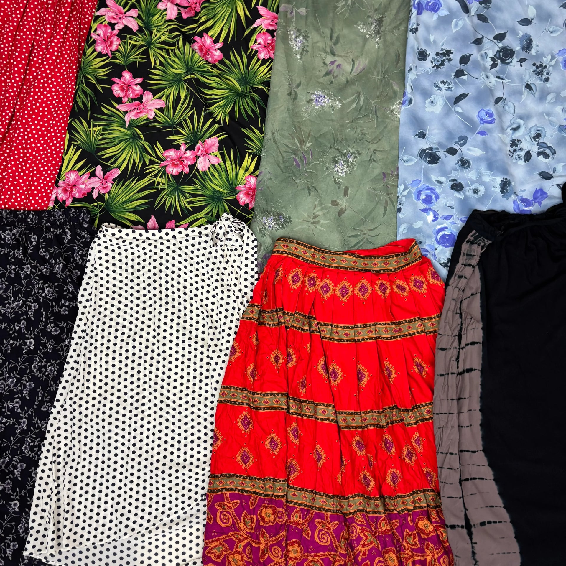 Collection of assorted vintage summer skirts with floral, polka dot, and patterned designs in vibrant colors.