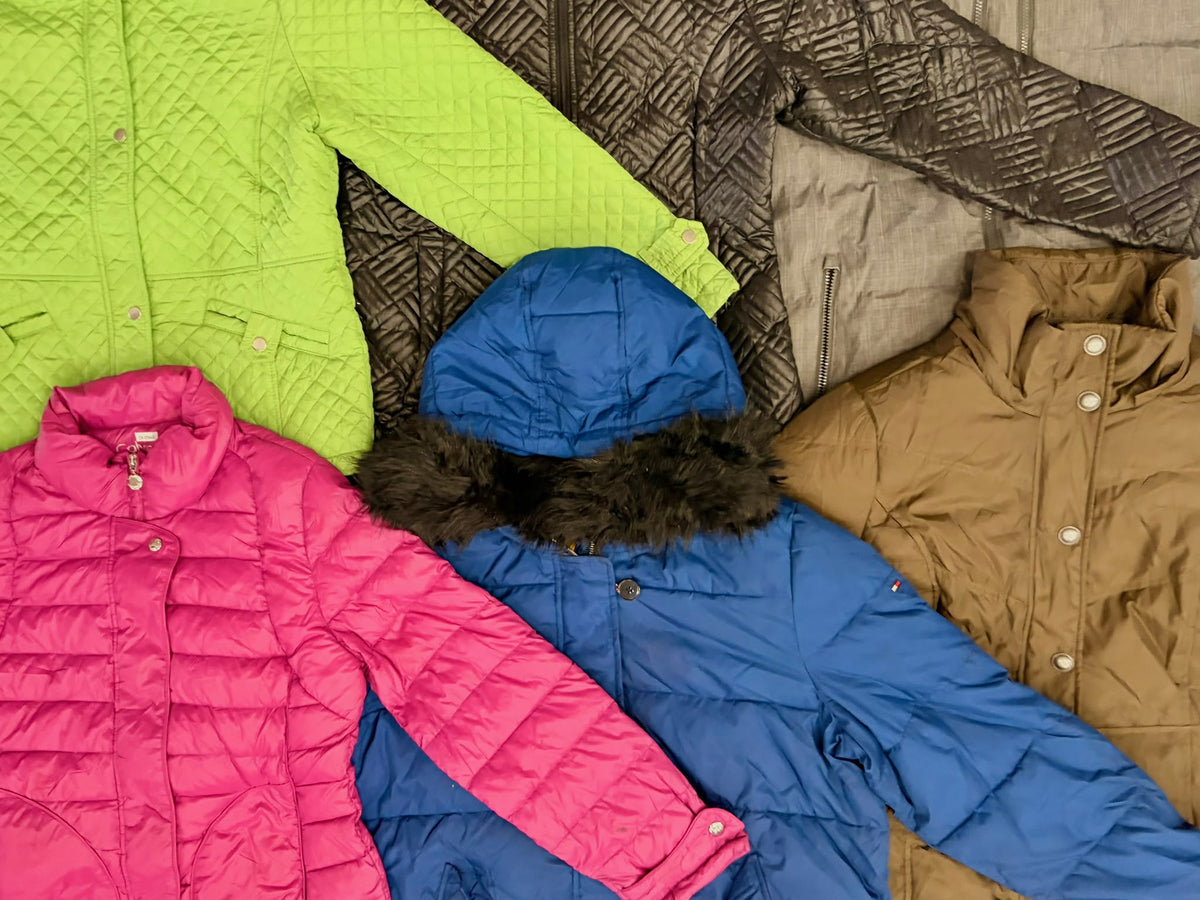 Bright pink, royal blue, lime green, and tan quilted jackets with padded panels and varied collars laid together.
