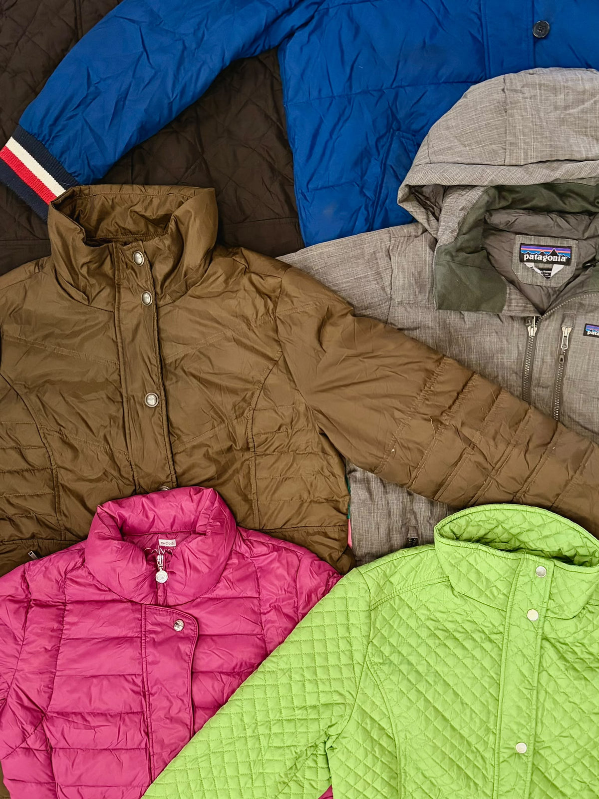 Four mixed quilted jackets in blue, brown, pink, and lime green, with snap fronts and ribbed cuffs.