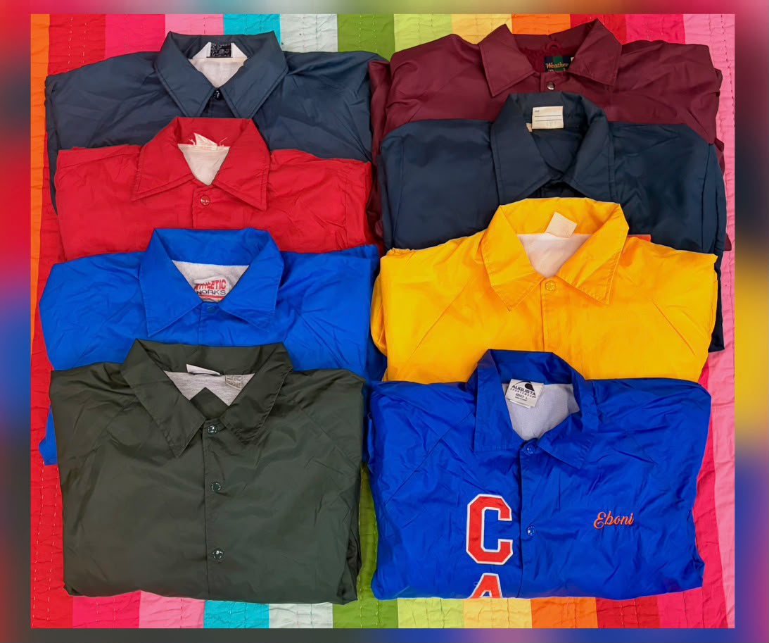 Assorted coach jackets in red, navy, blue, yellow, and olive, with snap fronts and assorted chest details.
