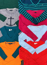 Assorted branded women's knitwear in teal stripes, gray, green, orange, red, and pale blue, with V-neck and crewneck styles.