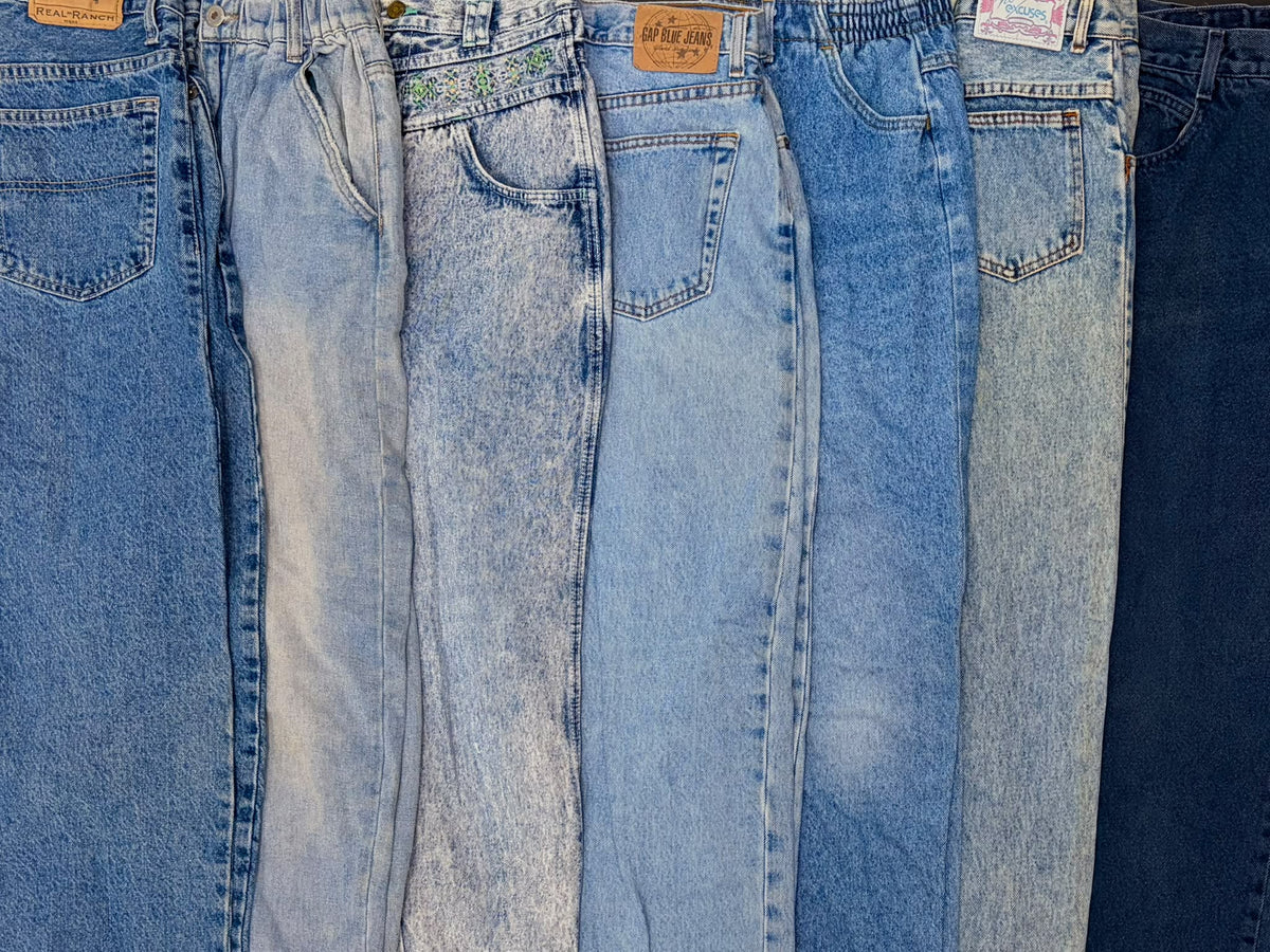 Four pairs of high-waisted mom jeans in varied blue washes, with relaxed legs and classic denim pockets.