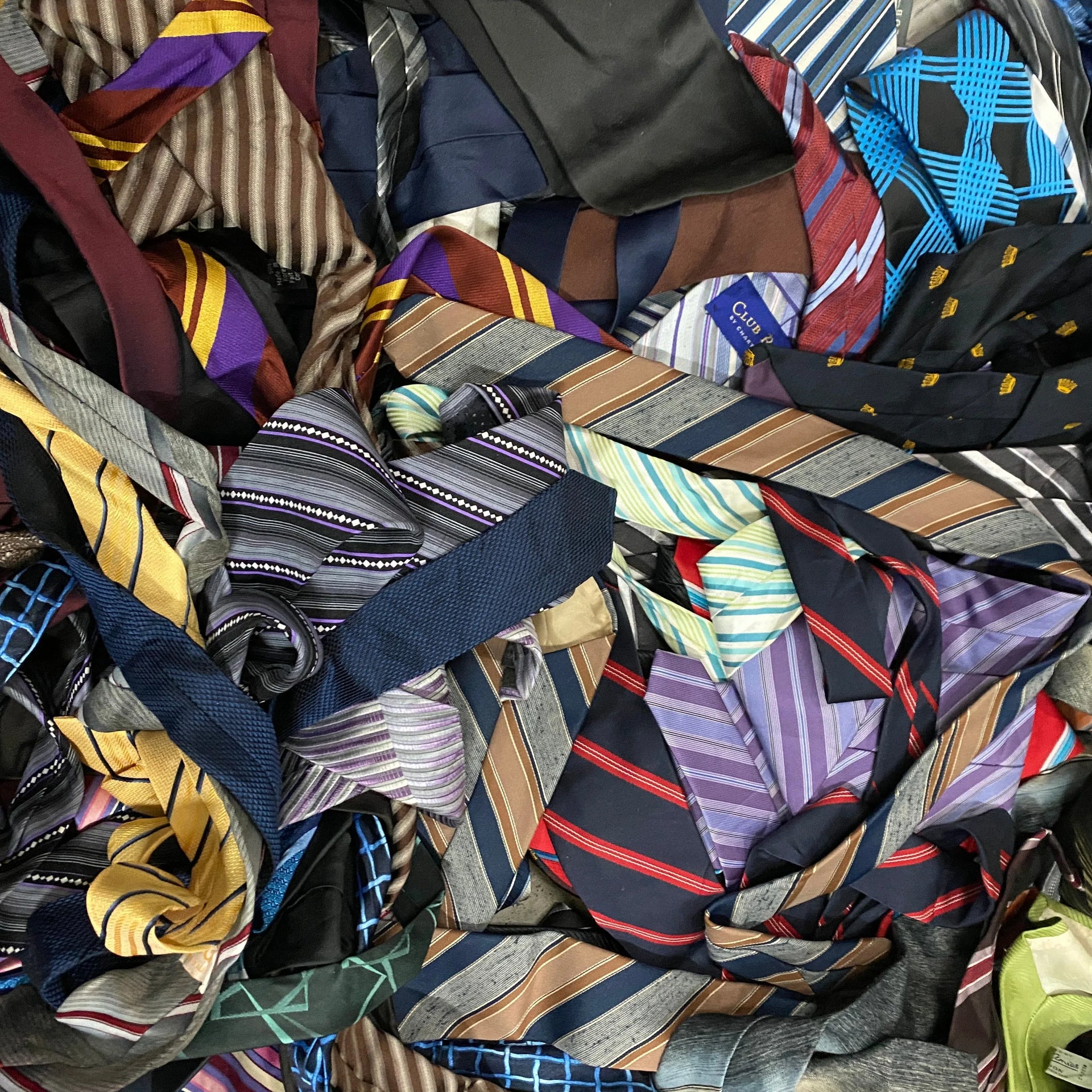 Assorted 50 mixed men's neckties in various colors, patterns, and stripes piled together.